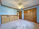 Blue bedroom with built-in storage, hardwood floors, and sliding closet doors at 5441 Red Hawk Ln, Greenwood, IN 46142