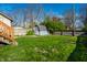A backyard featuring a green lawn, a fence, and a shed with a small deck at 5442 Hibben Ave, Indianapolis, IN 46219