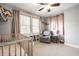Bright and cozy bedroom showcasing a comfortable armchair, baby crib and ample natural light at 5442 Hibben Ave, Indianapolis, IN 46219