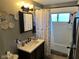 Well-lit bathroom featuring a vanity with a dark wood finish, decorative mirror, and a shower/tub combo at 5626 Hammon Dr, Brownsburg, IN 46112