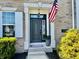Welcoming front door entrance with decorative accents, an American flag, and lush greenery at 5802 Bentbrook Dr, Bargersville, IN 46106