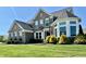 A stately home with a well manicured green lawn, flower boxes, and elegant brick facade at 5802 Bentbrook Dr, Bargersville, IN 46106
