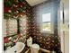 Unique powder room featuring sink, toilet, mirror, and exotic tropical-themed wallpaper at 5802 Bentbrook Dr, Bargersville, IN 46106