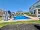 The backyard features a sparkling in-ground pool with a slide, surrounded by green lawn, perfect for summer relaxation at 5802 Bentbrook Dr, Bargersville, IN 46106