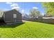 A well-kept backyard with a vibrant green lawn, enclosed by a wooden fence and a detached garage at 6164 Evanston Ave, Indianapolis, IN 46220