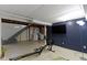 Unfinished basement space offering a exercise machine and large TV at 6164 Evanston Ave, Indianapolis, IN 46220