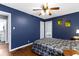 A primary bedroom has hardwood floors, ceiling fan, and a large bed at 6164 Evanston Ave, Indianapolis, IN 46220