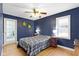 A primary bedroom has hardwood floors, ceiling fan, and a large bed at 6164 Evanston Ave, Indianapolis, IN 46220