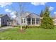 Charming gray home featuring a screened-in porch and a well-manicured lawn at 6164 Evanston Ave, Indianapolis, IN 46220