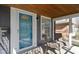 Inviting front porch with wood ceiling, blue door, and seating area at 6164 Evanston Ave, Indianapolis, IN 46220