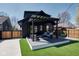 Inviting backyard with deck, pergola, modern furniture, and manicured lawn at 6173 Rosslyn Ave, Indianapolis, IN 46220
