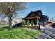 Beautifully landscaped front yard featuring a charming covered porch on a dark colored home at 6173 Rosslyn Ave, Indianapolis, IN 46220