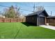 View of detached garage with artificial grass and privacy fence at 6173 Rosslyn Ave, Indianapolis, IN 46220