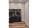 Modern laundry room featuring front-load washer and dryer set with cabinets above at 6173 Rosslyn Ave, Indianapolis, IN 46220