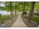 Grassy yard and stone walkway leading to the lake with dock at 7014 Eagle Dr, Nineveh, IN 46164