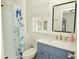 This bathroom has a shower with a fish curtain, a blue vanity, and modern fixtures at 7014 Eagle Dr, Nineveh, IN 46164