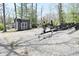Paved driveway, storage shed, and black ShoreLand'r boat trailer amidst lush trees at 7014 Eagle Dr, Nineveh, IN 46164