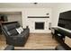 Cozy living room with white brick fireplace and dark wood mantle, and vinyl floors at 7014 Eagle Dr, Nineveh, IN 46164