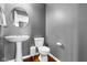 Cozy half bathroom featuring a pedestal sink and toilet against a neutral gray wall at 7128 English Oak Dr, McCordsville, IN 46055