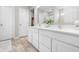 A bright bathroom offers a double vanity with white cabinets and quartz countertop at 7128 English Oak Dr, McCordsville, IN 46055