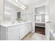 A bright bathroom provides a double vanity with white cabinets and quartz countertop at 7128 English Oak Dr, McCordsville, IN 46055