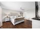 Cozy bedroom with dark wood floors, a bed with white accents, and a ceiling fan at 7128 English Oak Dr, McCordsville, IN 46055