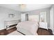 Bright bedroom featuring a plush bed, hardwood floors, chandelier, and mirrored drawers at 7128 English Oak Dr, McCordsville, IN 46055