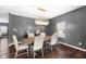 Elegant dining room with wood floors, modern chandelier, and stylish decor against gray walls at 7128 English Oak Dr, McCordsville, IN 46055