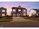 Beautiful two-story brick home with a two-car garage and manicured lawn, illuminated by the soft hues of twilight at 7128 English Oak Dr, McCordsville, IN 46055