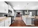 Bright kitchen featuring white cabinetry, stainless steel appliances, an island, and hardwood floors at 7128 English Oak Dr, McCordsville, IN 46055