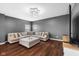 Inviting living room with a large sectional sofa, plush ottoman and modern light fixture at 7128 English Oak Dr, McCordsville, IN 46055