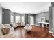 Inviting living area featuring hardwood floors, gray walls, a white door and trim, plus bright natural lighting at 7128 English Oak Dr, McCordsville, IN 46055