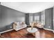 Comfortable living room featuring hardwood floors, gray walls, and contemporary furniture bathed in natural light at 7128 English Oak Dr, McCordsville, IN 46055