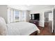 Bright main bedroom with hardwood floors, bay windows, and a large TV at 7128 English Oak Dr, McCordsville, IN 46055