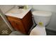 Bathroom with a wooden vanity, white sink, and a modern toilet, offering functionality at 7838 Burr Oak Ct, Indianapolis, IN 46217