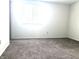 Bright bedroom with a large window, neutral carpet, and white walls, ready for personalization at 7838 Burr Oak Ct, Indianapolis, IN 46217