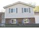 Close-up of a split-level home with a brick base, vinyl siding, and blue shutters at 7838 Burr Oak Ct, Indianapolis, IN 46217