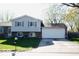 Well-maintained split-level home featuring blue shutters, brick accents, and an attached garage at 7838 Burr Oak Ct, Indianapolis, IN 46217