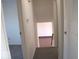 Hallway featuring carpeted stairs, a view to another room, and access to the upper level at 7838 Burr Oak Ct, Indianapolis, IN 46217