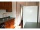 Galley kitchen featuring wood cabinets, black appliances, and a stainless steel sink at 7838 Burr Oak Ct, Indianapolis, IN 46217