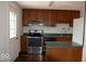 Compact kitchen with wooden cabinets, stainless steel appliances, and access to the backyard at 7838 Burr Oak Ct, Indianapolis, IN 46217