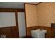 Functional laundry room area featuring durable paneled walls and vintage wallpaper at 7838 Burr Oak Ct, Indianapolis, IN 46217