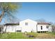 The rear exterior features white siding, a compact yard, and a pleasant, simple design under a clear sky at 7838 Burr Oak Ct, Indianapolis, IN 46217