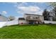 Exterior rear view of a home with a deck, stairs, lawn, and play equipment at 8231 N Chaucer Ct, Columbus, IN 47201