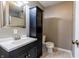 Bathroom features a vanity with sink, mirror, tiled floors, and a combined storage and toilet area at 8231 N Chaucer Ct, Columbus, IN 47201