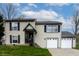Charming two-story home featuring a welcoming entrance and an attached two-car garage at 8231 N Chaucer Ct, Columbus, IN 47201