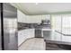 Modern kitchen with white cabinets, stainless steel appliances, and a dark backsplash for contrast at 8231 N Chaucer Ct, Columbus, IN 47201