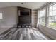 Spacious living room featuring a custom TV unit, bright windows, and stylish hardwood floors at 8231 N Chaucer Ct, Columbus, IN 47201