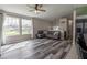 Open-concept living room with large windows, a ceiling fan, and seamless access to the kitchen area at 8231 N Chaucer Ct, Columbus, IN 47201