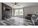 Bright living room featuring a modern TV unit, hardwood floors, and a comfortable sectional sofa at 8231 N Chaucer Ct, Columbus, IN 47201